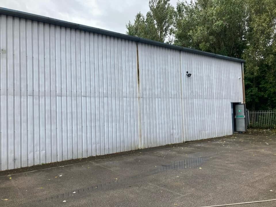 Industrial unit cladding before spray coating, faded and weathered