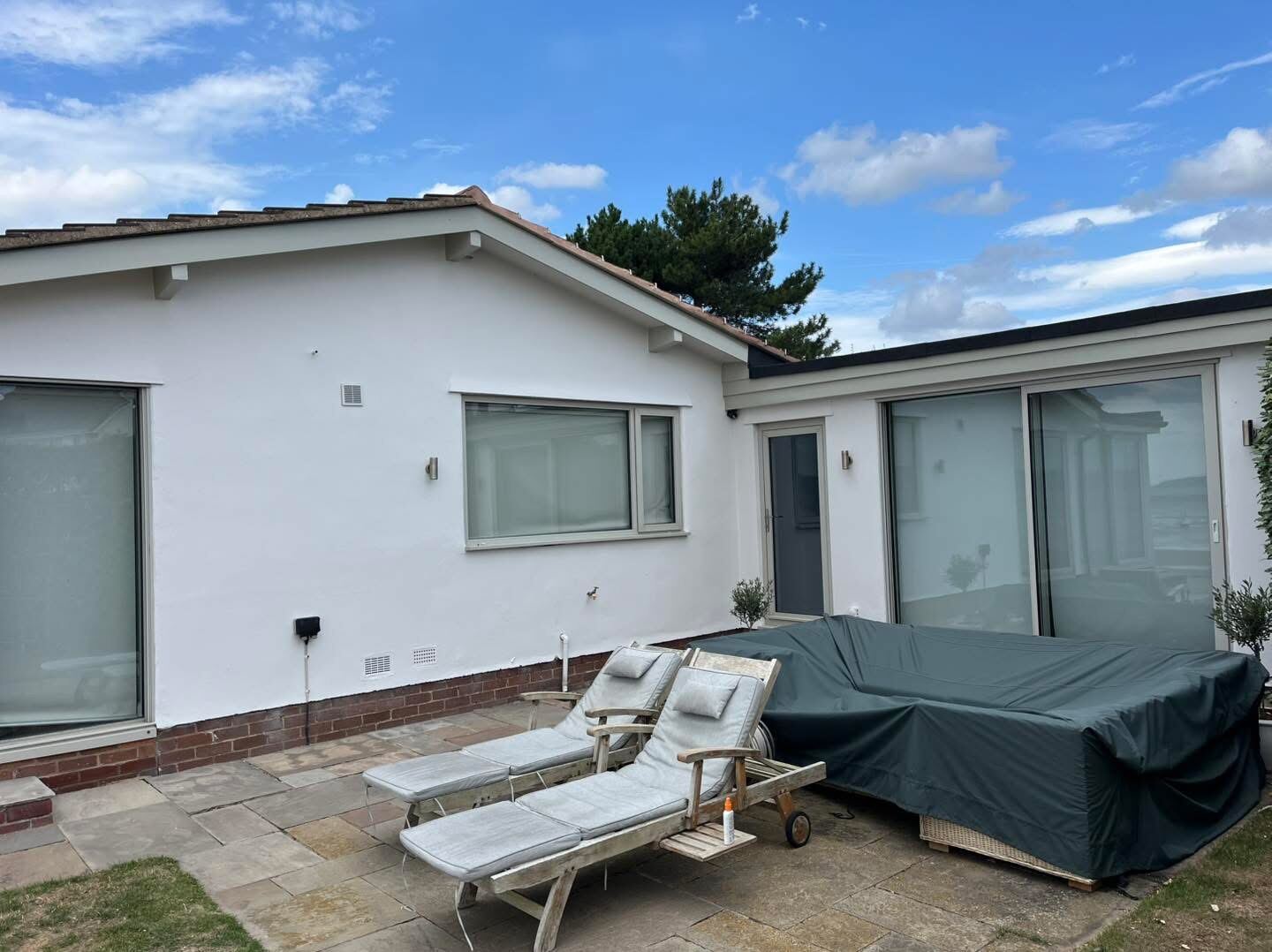 Bungalow exterior after repaint, crisp white finish