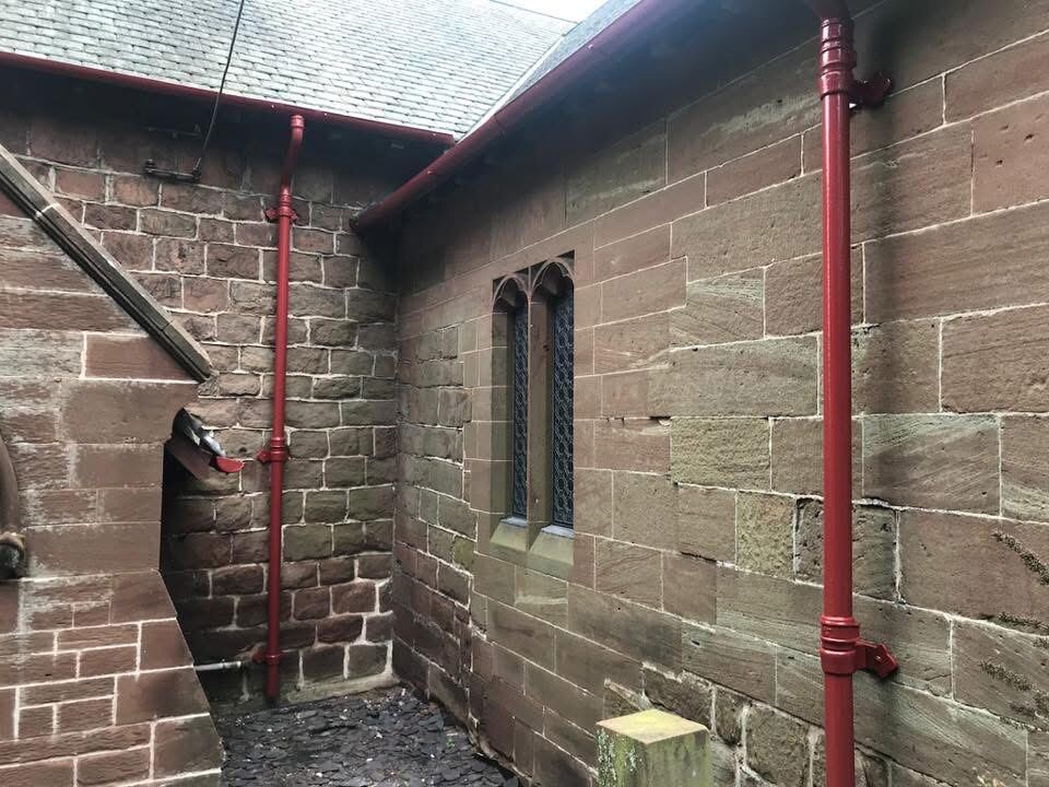 Church exterior with restored red drainpipes