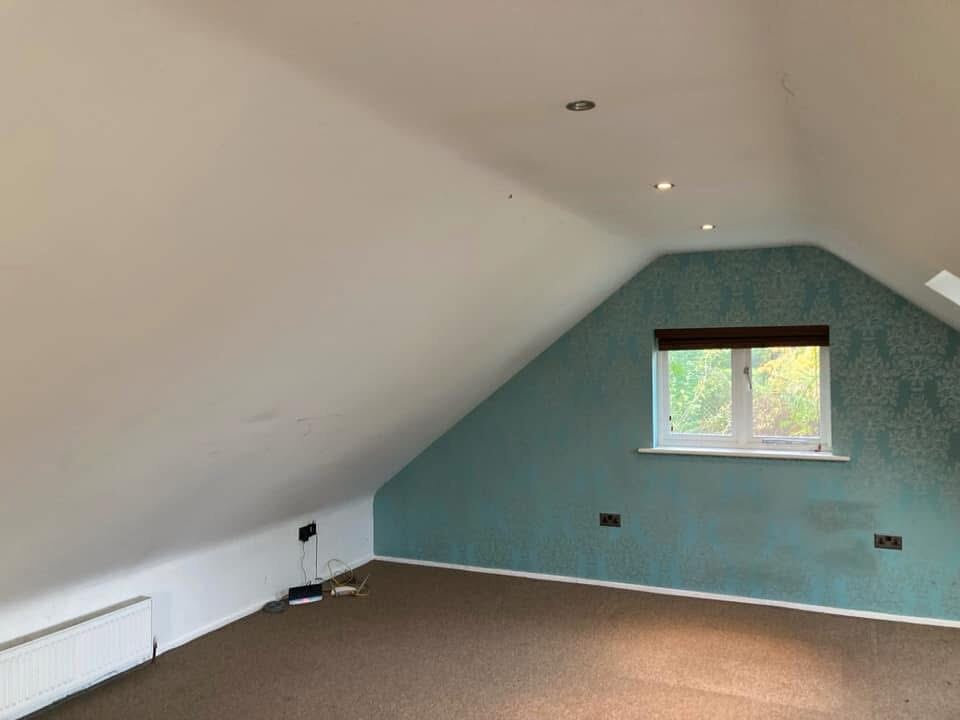 Loft bedroom with sage green feature wall